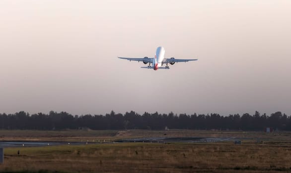 Large passenger airplane is taking off from the runway
