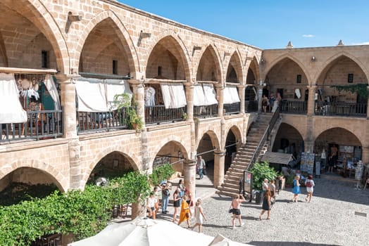 Nicosia, Cyprus - October 24, 2022: Tourists walking and shopping in Buyuk Han, the largest caravanserai in Nicosia, Cyprus during a sunny day