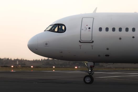 Large passenger airplane on the runway with a pilot in the cockpit