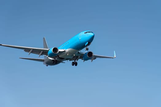 Large passenger plane is approaching an airport on a sunny day