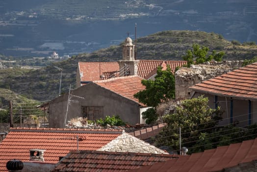 Traditional stone houses with tile roofs are illuminated by the afternoon sun in Vouni village, Cyprus