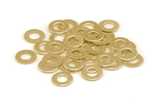 A pile of gold coloured washers on white background