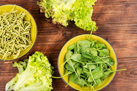 A plate of spaghetti with vibrant dry green pasta with spinach