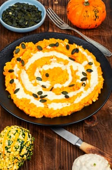 Autumn pumpkin risotto with parmesan cheese on wooden rustic background.