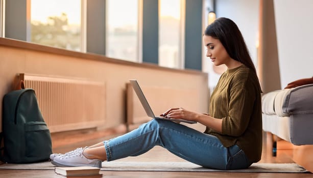 young female student seated on the floor with laptop pc, AI generated image