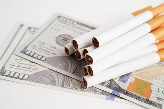 Cigarette on US dollar banknotes, cost, trading, marketing and production, No smoking concept.