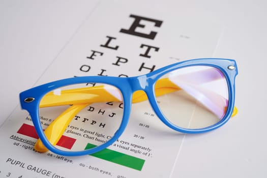 Glasses on eye exam chart to test eyesight accuracy of reading.