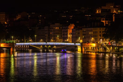 Cityscape of Lyon, France with reflections in the water at night
