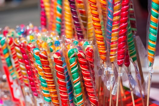 Close up of colorful handmade swirl lollipops on street market