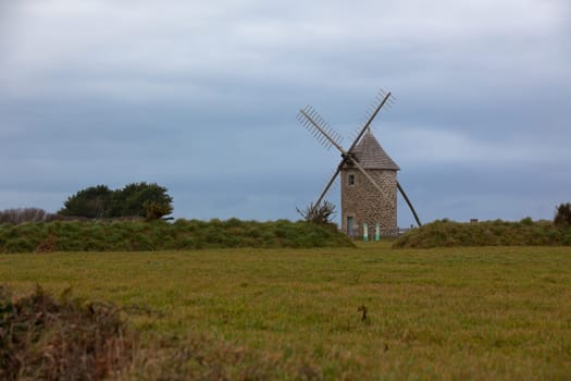 Dull Landscape with Old windmill in Brittany, Western France. Toned image