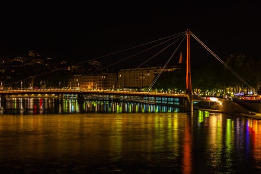 Cityscape of Lyon, France with reflections in the water at night