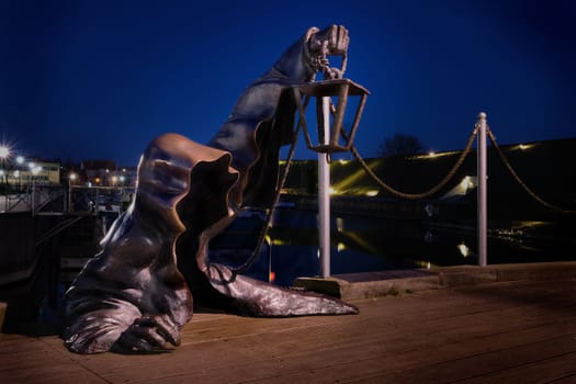 City attraction - statue in old port of Klaipeda, Lithuania. Legend of black no-face ghost with a lantern in gnarled hand come out of harbor waters.