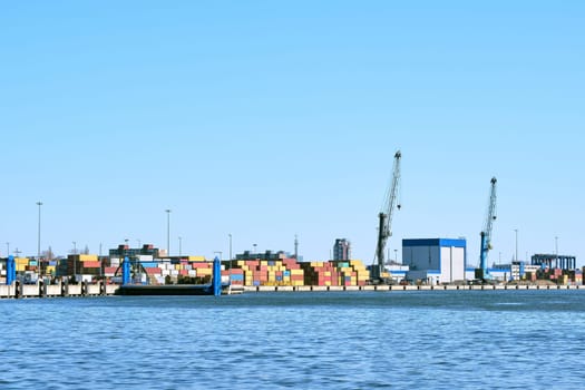 View of port cranes, loading bridges and container terminal. Sea trade, transportation, commerce and cargo