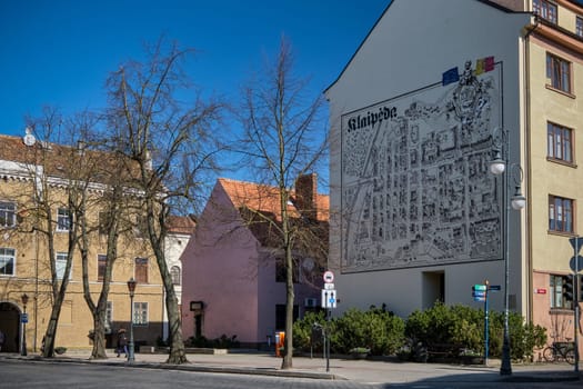 View of an old street in Klaipeda, Lithuania with old buildings and house, city wall map on a sunny day in spring.