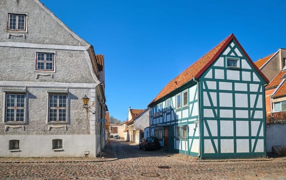 Typical fachwerk house of old Klaipeda, Lithuania medieval town and cobbled pavement street. German style buildings of Middle Ages.