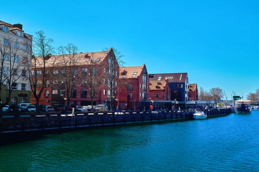 Jetty for boats and yachts in Klaipeda, Lithuania, on sunny day. Beautiful view of vessels and fachtwerk and red-brick houses.