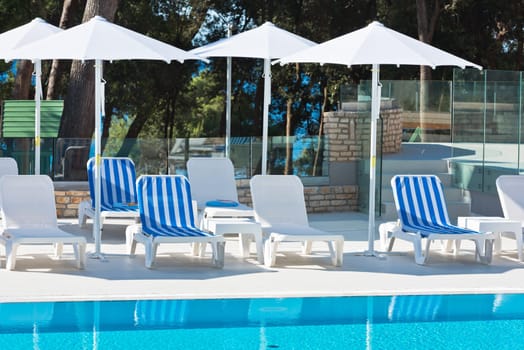 Hotel Poolside Chairs with Sea view. Summer shot