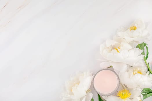 Beautiful blooming white peony flowers on marble background with copy space in minimal style, template for postcard, lettering, text or your design. Wedding invitation and celebration greeting concept