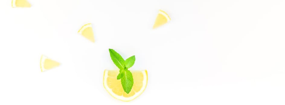 Long wide banner top view citrus lemon slices and mint herbs leaves white table background with copyspace. Hot summer refreshment lemonade concept. Beverage ingredients arranged