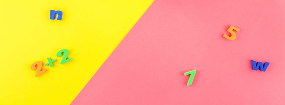 Creative flat lay back to school concept with welcome letters message on bright yellow and pink paper background with copy space, template for text or design. Long wide banner