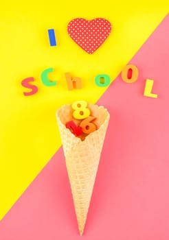 Creative flat lay back to school concept with waffle cone and welcome letters message on bright yellow and pink paper background with copy space, template for text or design