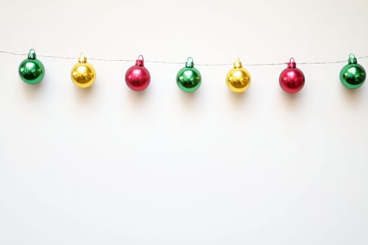 Vibrant holiday garlands display an array of shiny ornaments in red, green, and gold, creating a festive atmosphere against a clean, minimalist background perfect for seasonal celebrations.
