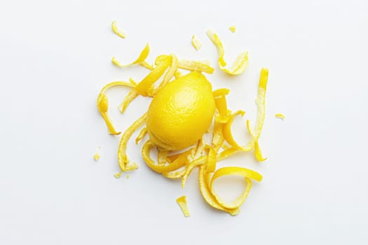 Bright yellow lemon zest is beautifully arranged with fresh peel scattered around it. This vibrant composition highlights the zests texture, ideal for enhancing dishes or drinks.