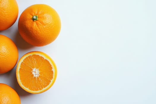 A collection of fresh oranges showcases their bright color against a clean white background, inviting a sense of freshness and health. One orange is sliced in half, revealing its juicy interior.