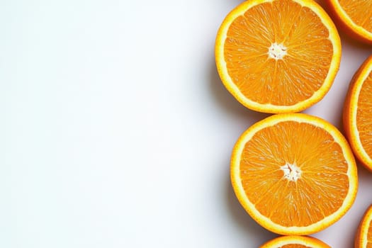 The bright orange slices are arranged neatly on a smooth white background, highlighting their freshness and vibrant color.