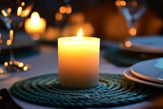 A flickering candle creates a serene ambiance on a beautifully arranged dinner table adorned with sparkling glassware.