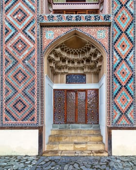 Detailed side entrance of Shaki Khan Palace, featuring vibrant tile patterns and elegant design in Shaki, Azerbaijan
