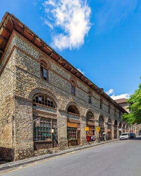 Shaki, Azerbaijan - May 15, 2024: The Upper Karvansaray features impressive stone architecture with arched windows and vibrant shops. The building aligns with a clear blue sky