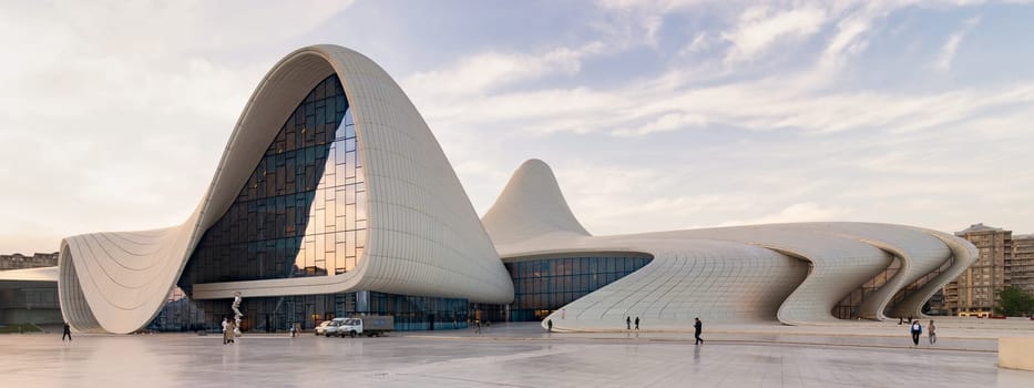 Baku, Azerbaijan - May 11, 2024: The Heydar Aliyev Centre showcases its unique fluid design and striking angular lines, bathed in warm sunset light