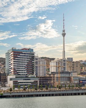 The Baku TV Tower rises alongside contemporary tall buildings against the backdrop of the Caspian Sea over the city of Baku, Azerbaijan