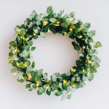 A beautiful green wreath adorned with twinkling fairy lights enhances the ambiance of a cozy indoor space.