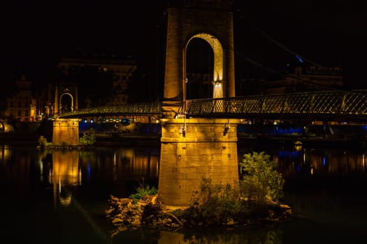 Old Passerelle du College bridge over Rhone river in Lyon, France at night