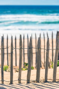 Wooden fence on an Atlantic beach in France, The Gironde Department. Shot with a selective focus