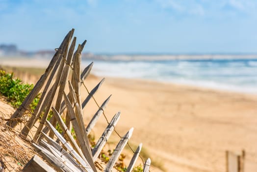 Wooden fence on an Atlantic beach in France, The Gironde Department. Shot with a selective focus