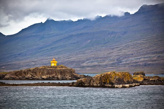 Iceland Sea and Mountains Landscape with Orange Lighthouse. Horizontal shot