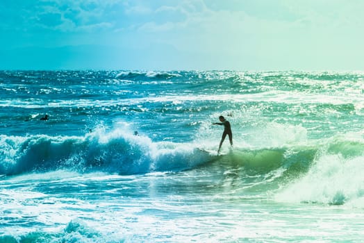 Extreme surfers riding some waves on the sea in France