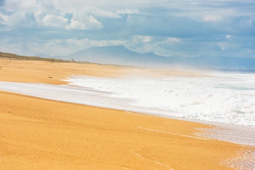 Long Sand Atlantic Beach with ocean waves. The Gironde Department, France. Shot with a selective focus