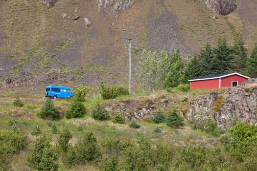 East Iceland Nature Landscape with rocks range, red house and blue minibus