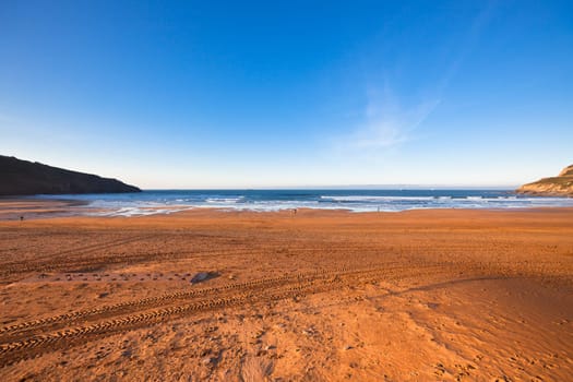 The Bay of Biscay near Bilbao, Spain in January: long beach and ocean before sunset time