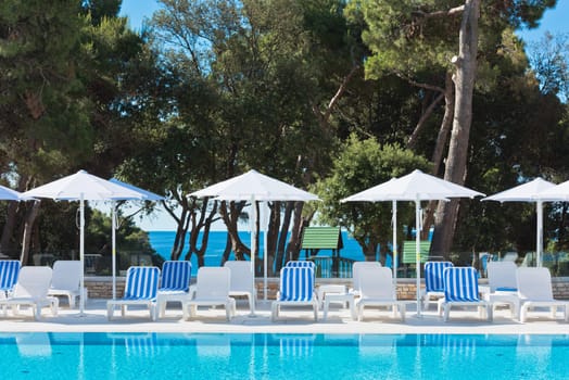 Hotel Poolside Chairs with Sea view. Summer shot