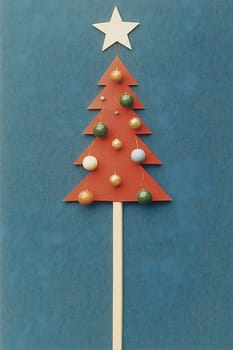 A handcrafted paper Christmas tree featuring colorful ornaments and a star, showcasing holiday spirit against a bright blue backdrop.