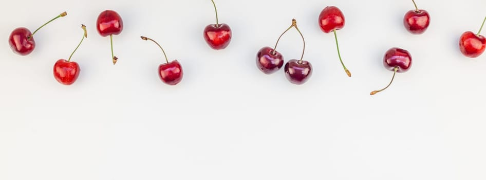 Long wide banner of fresh ripe cherry pattern layout with copy space isolated on white background in minimal style. Concept of summer fun and healthy eating. Template for your text or food design