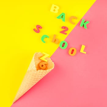 Square Creative flat lay back to school concept with waffle cone and welcome letters message on bright yellow and pink paper background with copy space, template for text or design
