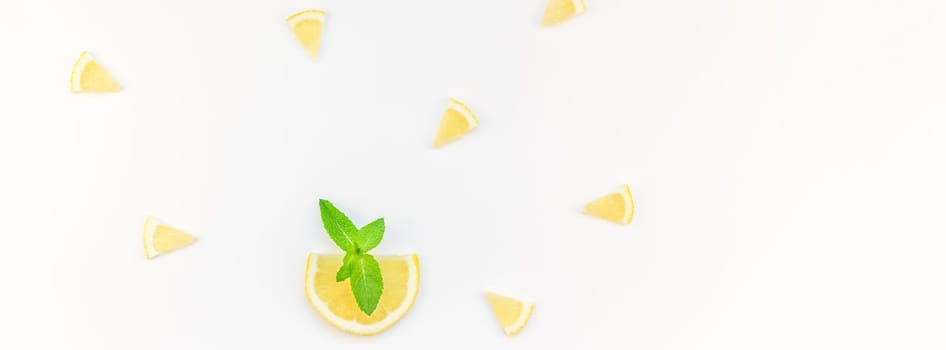 Long wide banner top view citrus lemon slices and mint herbs leaves white table background with copyspace. Hot summer refreshment lemonade concept. Beverage ingredients arranged