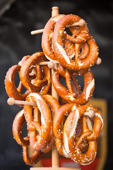 Pretzels - traditional german snacks are hanging on the wooden stand