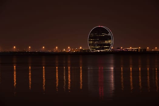 UAE, ABU DHABI - DECEMBER 20: View of Aldar headquarters building and night skyline of Abu Dhabi, UAE on December 20, 2014